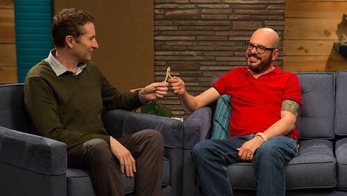 David Cross Wears a Red Polo Shirt and Brown Shoes with Red Laces