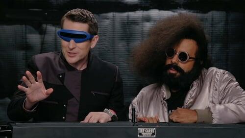 Reggie Watts Wears a Purple and Yellow Quilted Sweatshirt